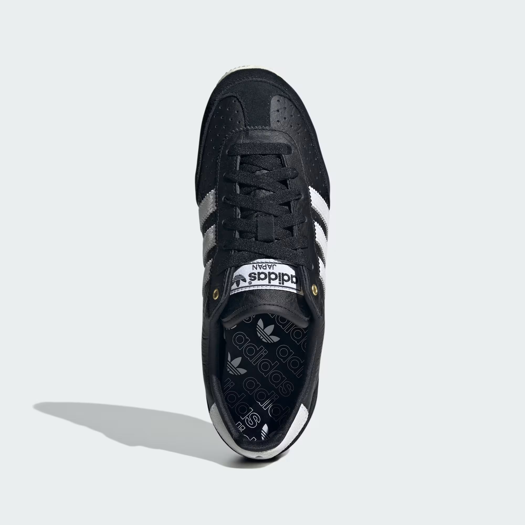 Side view of Adidas Womens Japan limited edition sneakers with black leather and white suede overlays
