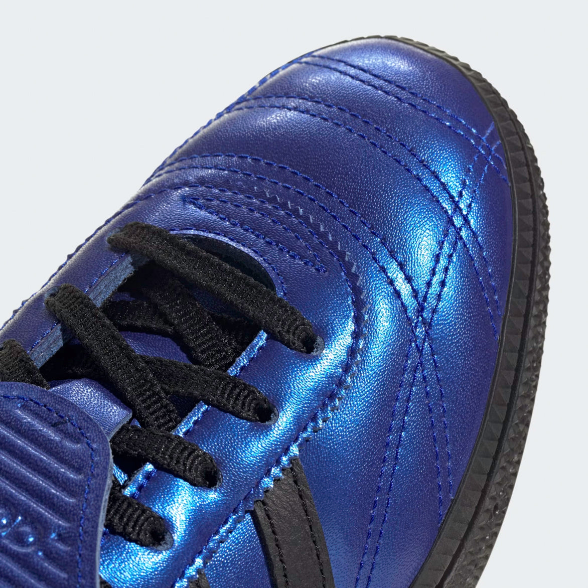 Side view of retro women’s sneakers in Lucid Blue and Core Black with logo details