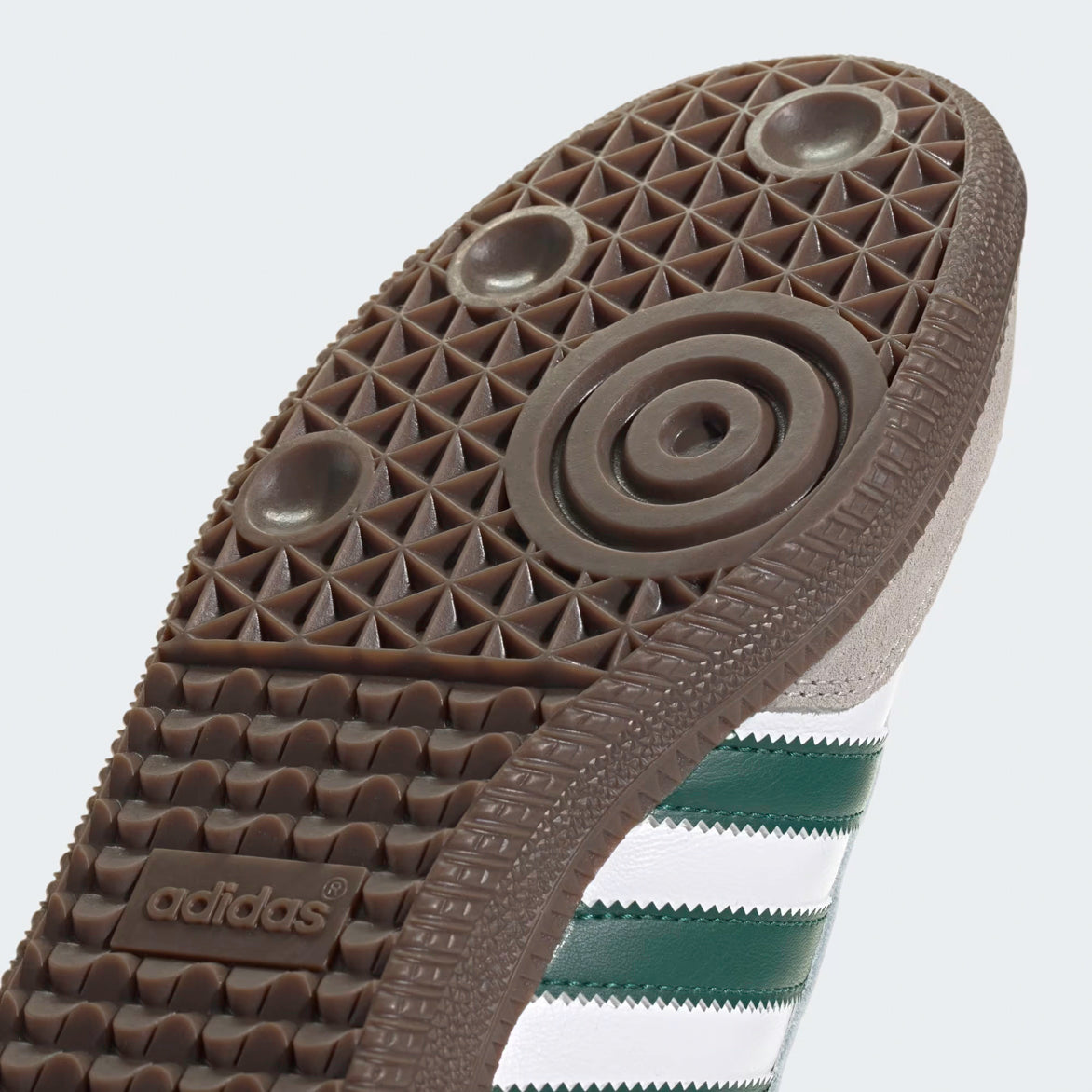 Top-down flat lay of limited edition Adidas Samba shoes with matching white laces, gold tongue tag, and green heel tab