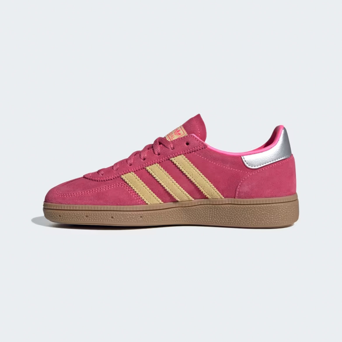 Side angle of lucid-pink suede Handball Spezial retro shoes on model wearing cropped denim