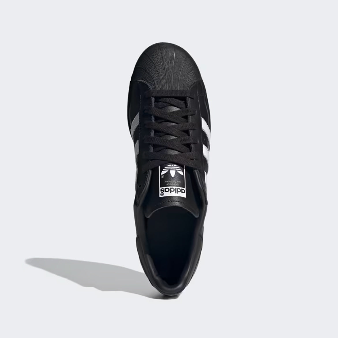 Close-up of rubber shell toe and trefoil logo on sneaker