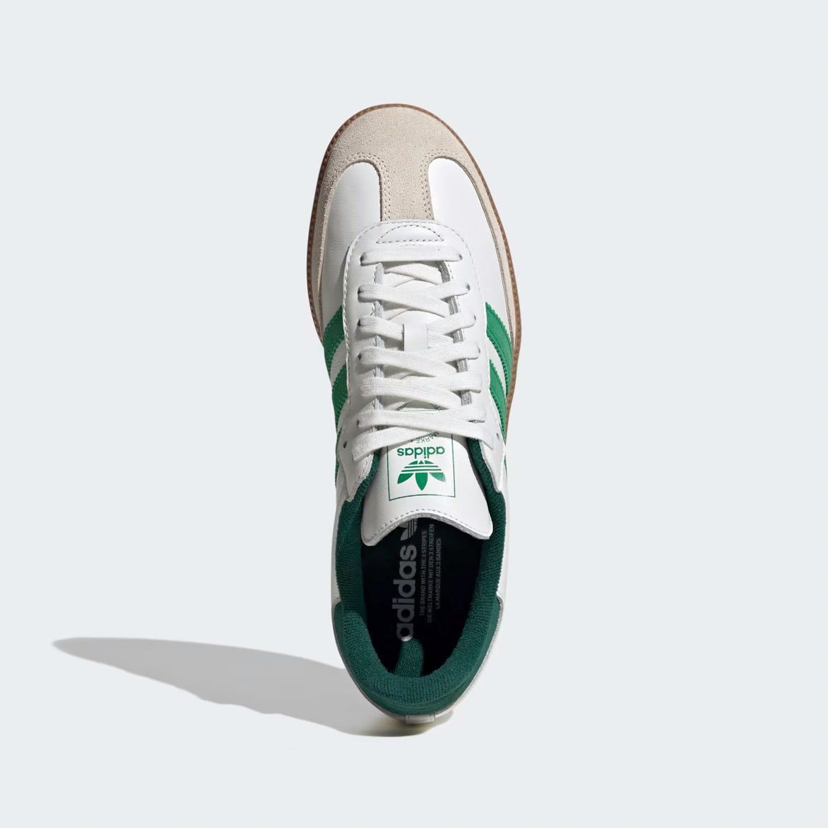 Side view of Adidas Samba OG white and green sneakers highlighting the leather upper and green accents