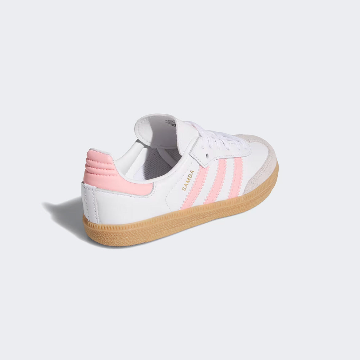 Lifestyle shot of kids wearing Adidas Samba OG white sneakers with pink details on the playground