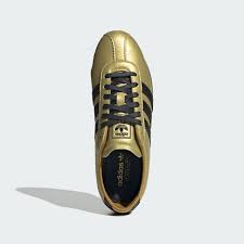 Close-up of metallic gold leather sneaker with serrated 3-Stripes and Tokyo Olympic tribute