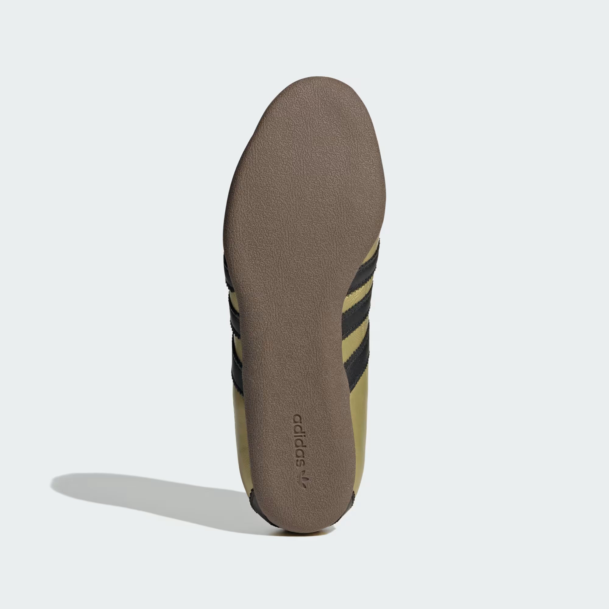 Top-down flat lay of cheap metallic sneakers for women highlighting gold foil branding and Trefoil stamp
