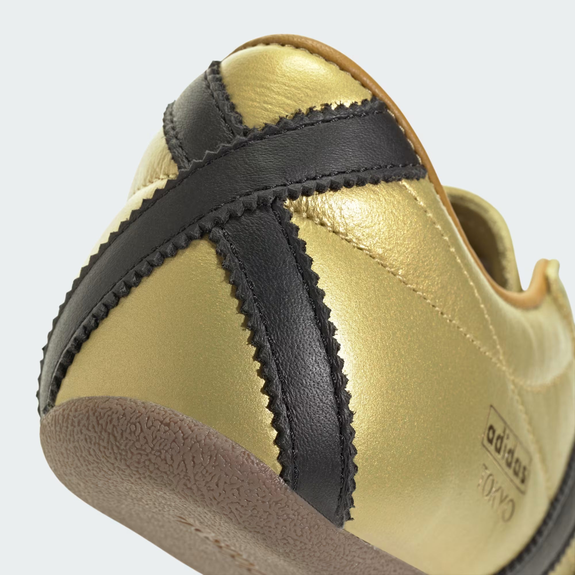 Side angle of womens stylish adidas sneakers on white background showing slim silhouette and gum sole texture