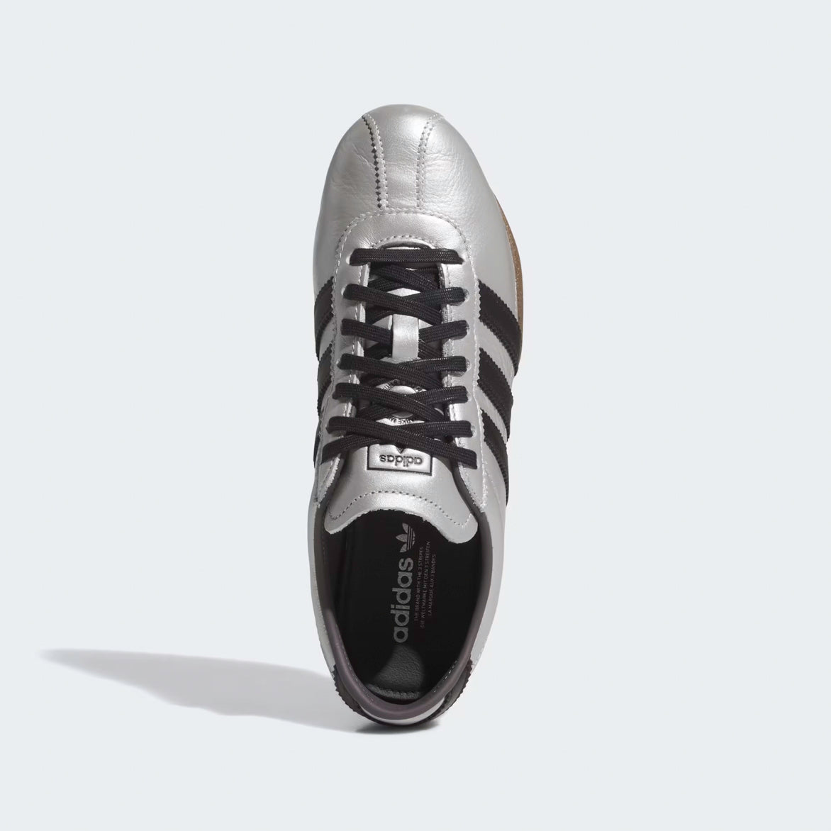 Side view of Adidas Womens Silver Metallic Sneakers, highlighting serrated overlays and low-profile sole.