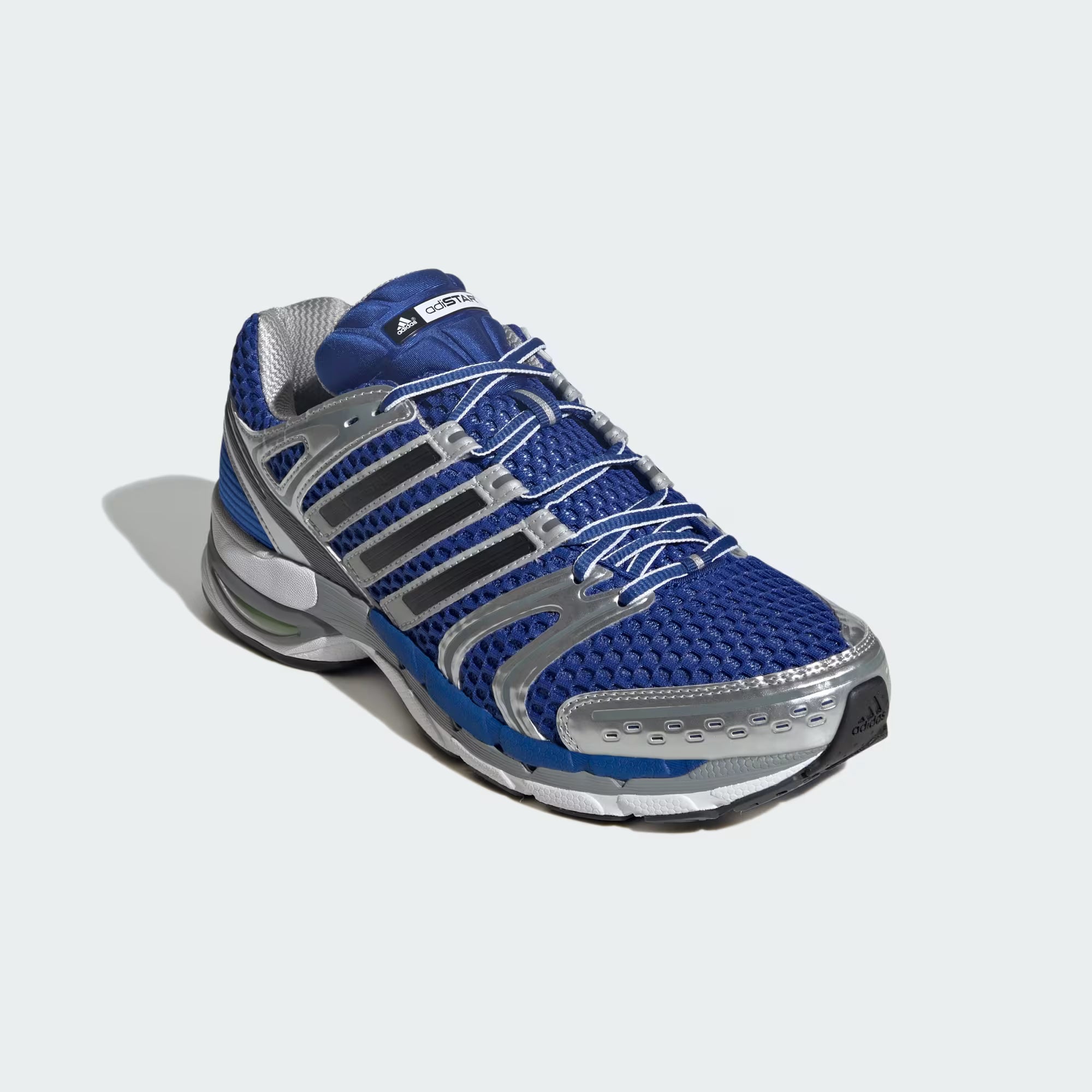 Close-up of the mesh upper and detailing of Adidas Adistar Control 5 sneakers, highlighting breathability and design.