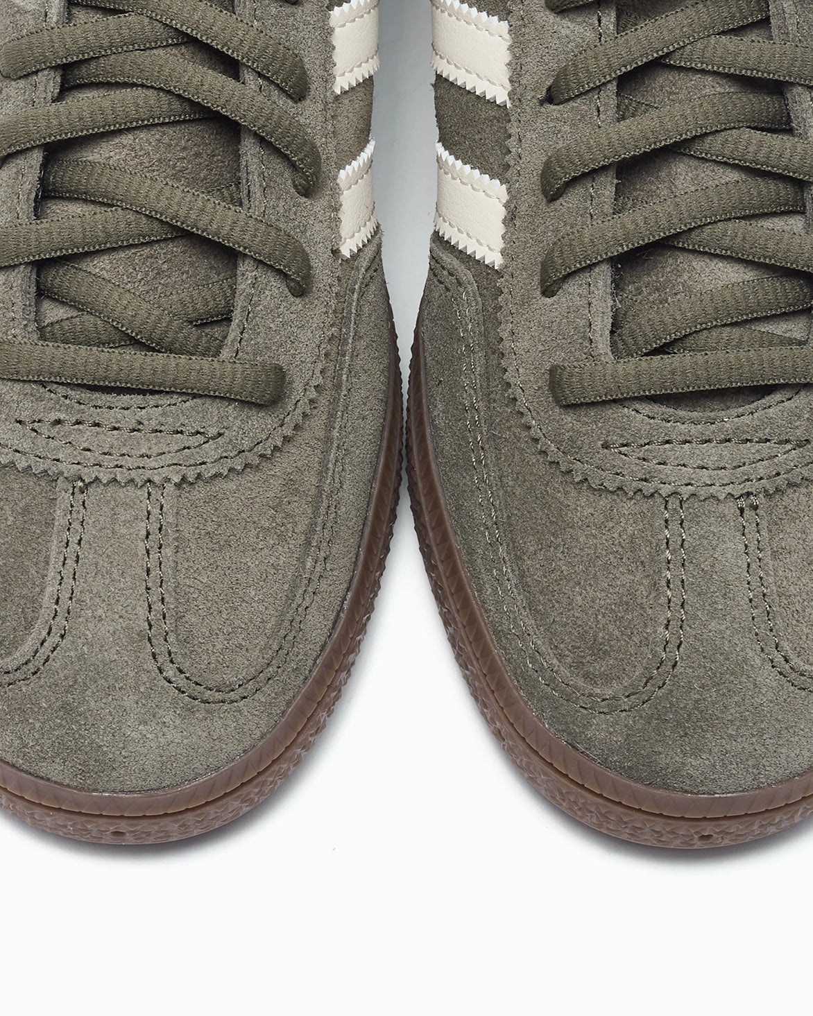 Top angle of limited edition olive green sneakers highlighting the suede and leather materials.