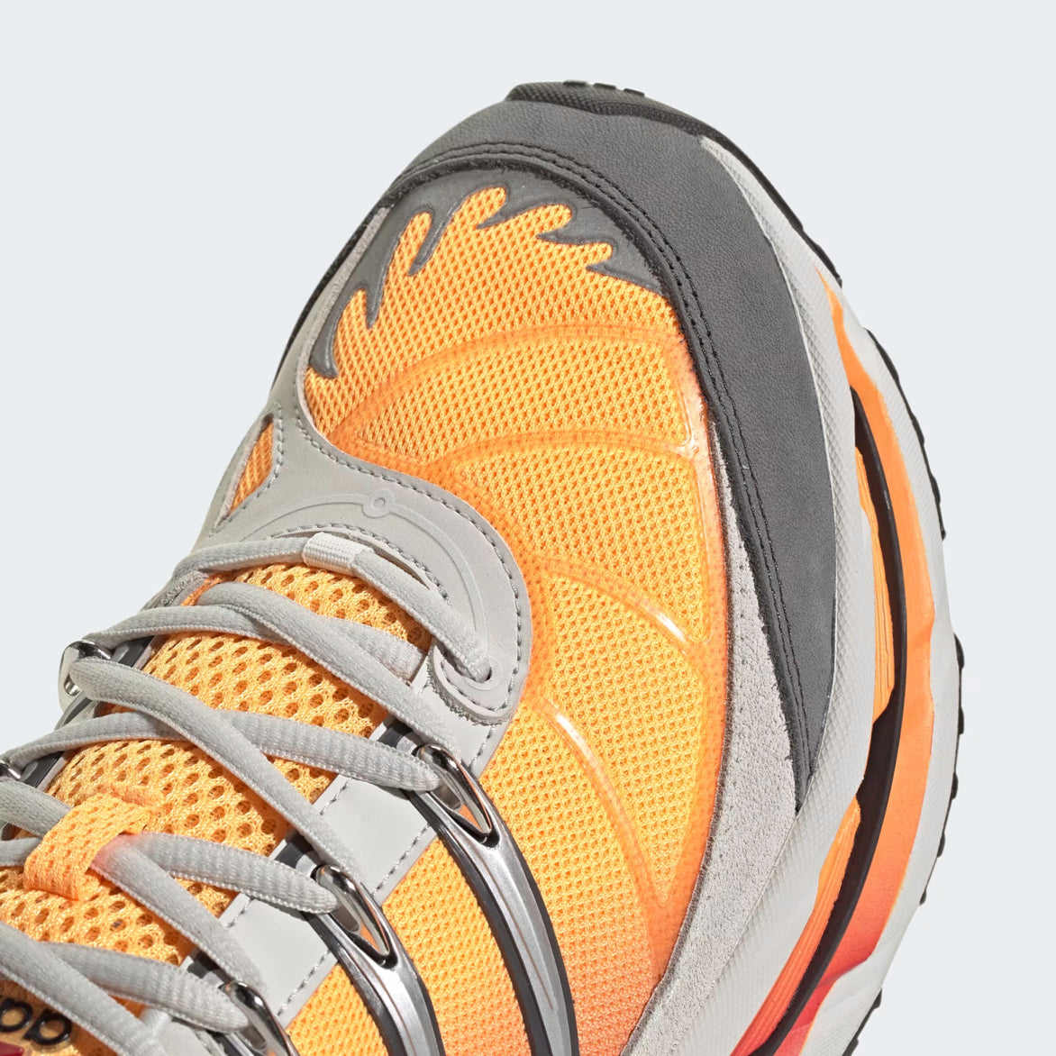 Top view of the Adidas Adistar HRMY sneakers highlighting the gradient orange mesh toe and metallic eyelets for a sporty yet casual look.