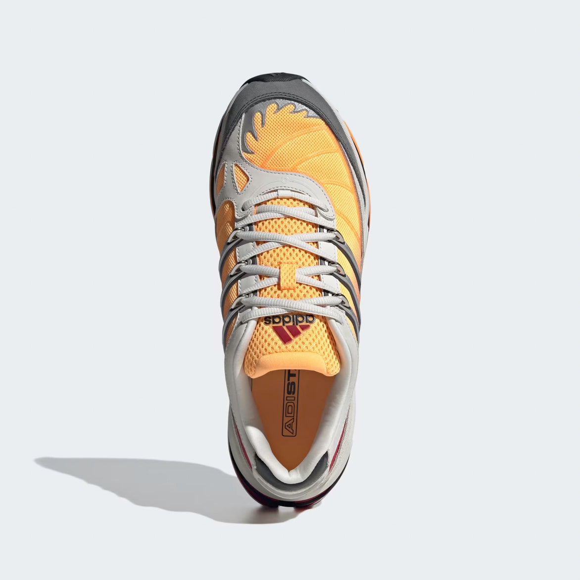 Side view of Adidas Adistar HRMY limited edition sneakers with grey and red accents, showcasing the synthetic overlays and 3-Stripes.