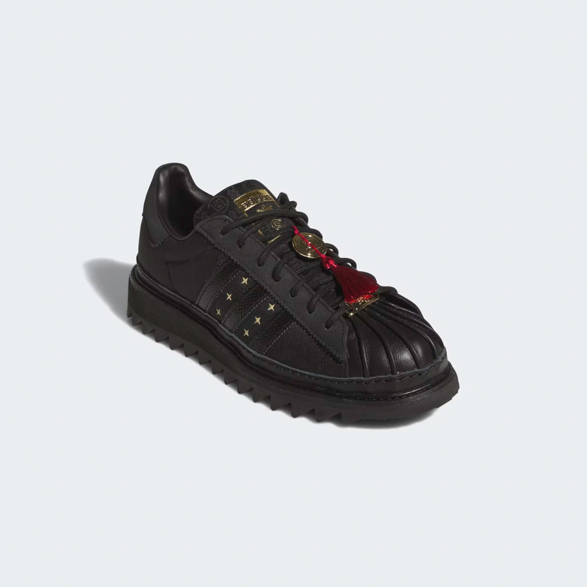 Side profile of limited edition adidas superstar in Core Black with ripple sole on city street