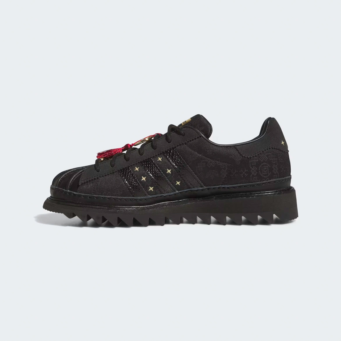 Side profile of limited edition adidas superstar in Core Black with ripple sole on city street