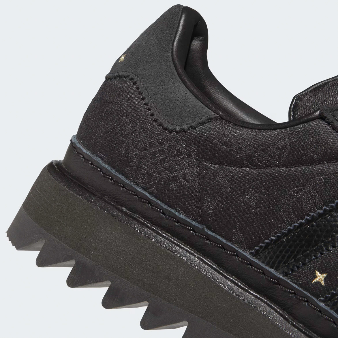 Side profile of limited edition adidas superstar in Core Black with ripple sole on city street