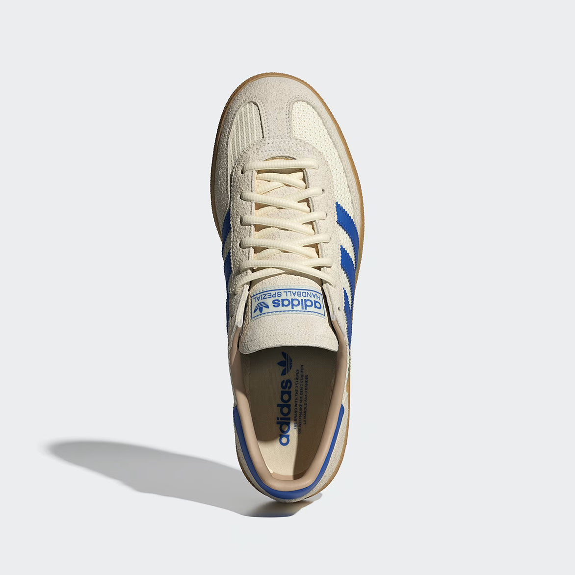 Front view of cream white and blue retro sneakers with gum outsole