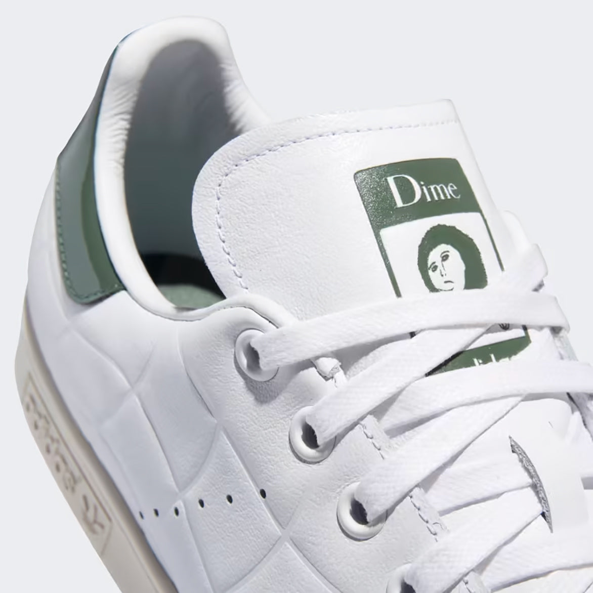 Side view of DIME x Adidas Stan Smith sneakers in Cloud White and Green Oxide