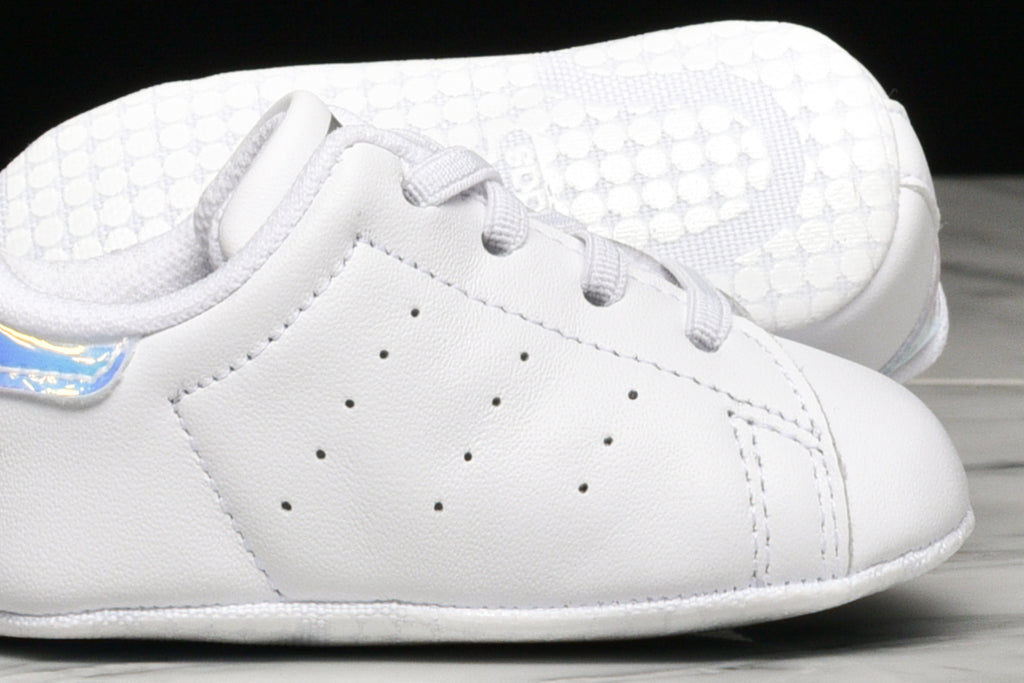 Adidas Stan Smith crib shoes in white with metallic silver accents, perfect for toddlers.