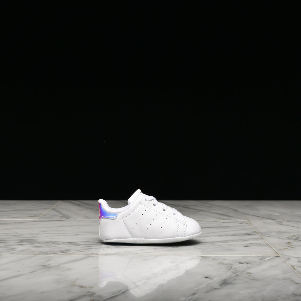 Adidas Stan Smith crib shoes in white with metallic silver accents, perfect for toddlers.