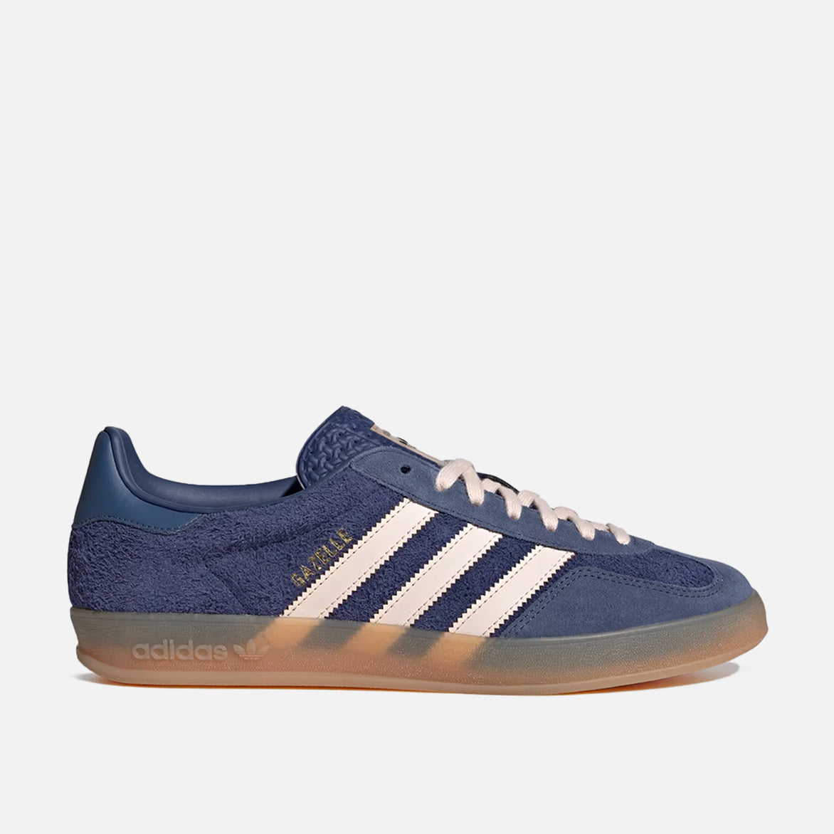 Side view of premium blue sneakers with gum sole, showcasing tonal suede and gold accents.