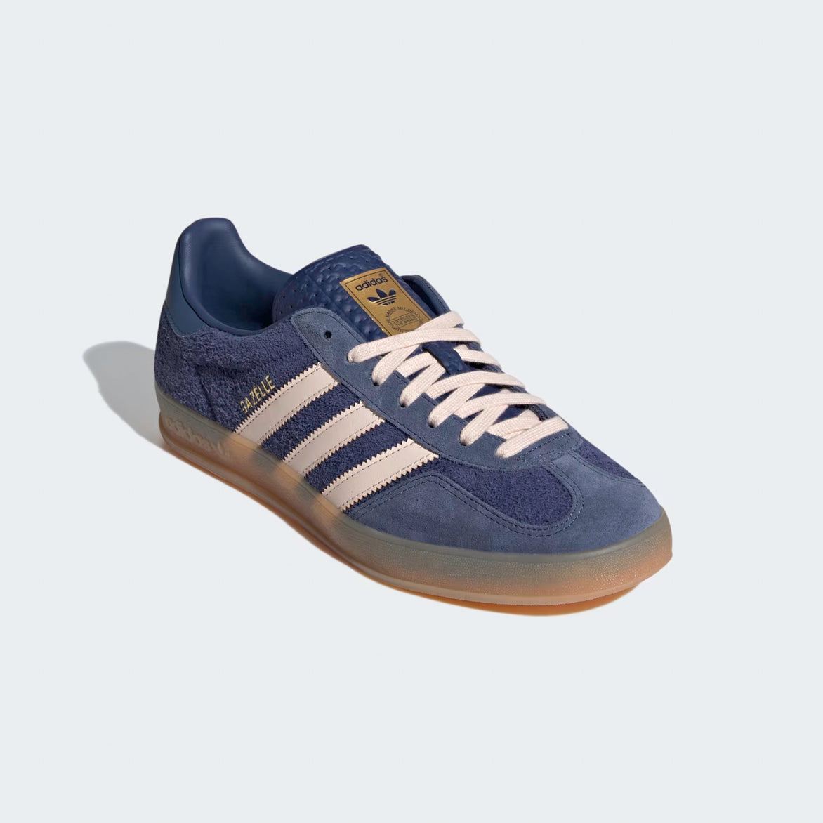 Top view of blue sneakers highlighting the textured tongue and off-white laces.