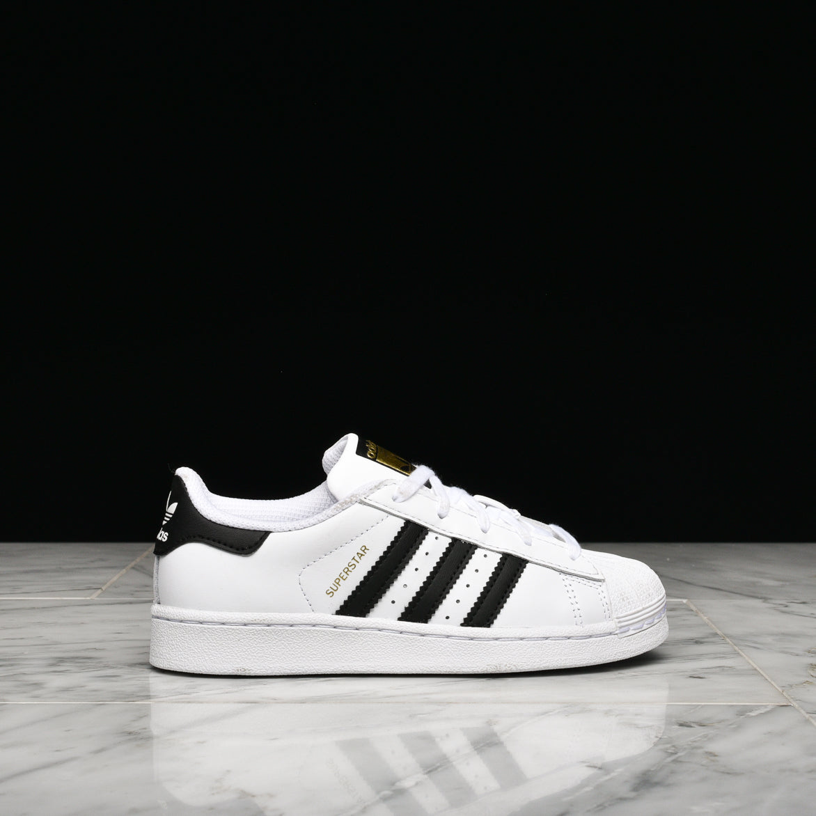 adidas Superstar white sneakers with rubber shell toe and leather overlays, front view