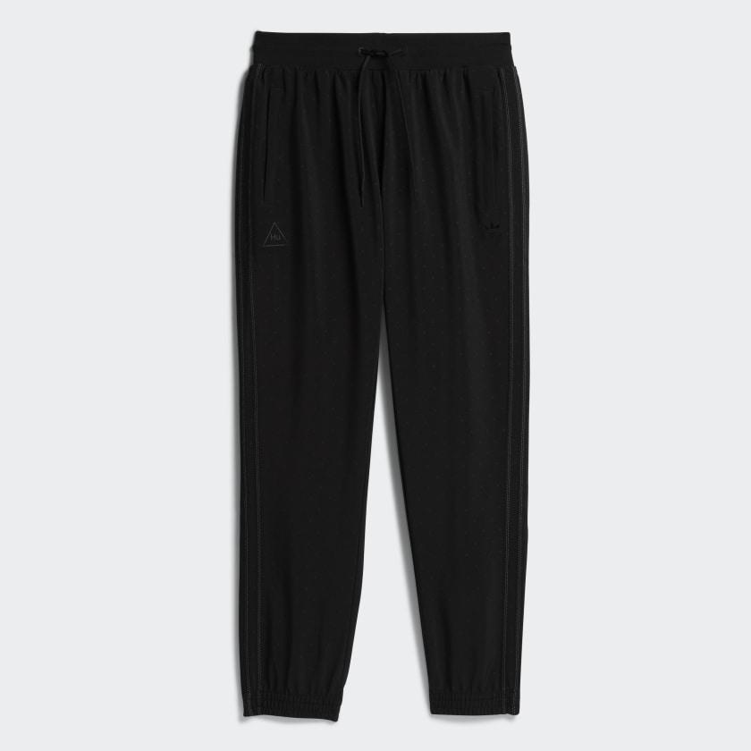 Close-up of Pharrell x adidas track pants with reflective print showing side detail