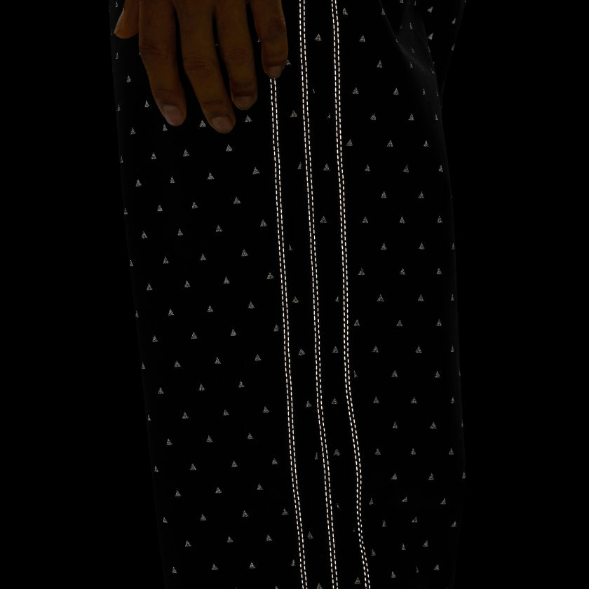 Close-up of Pharrell x adidas track pants with reflective print showing side detail