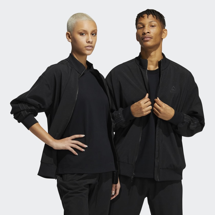 Model wearing the Pharrell x adidas black track jacket, highlighting its fit and reflective accents