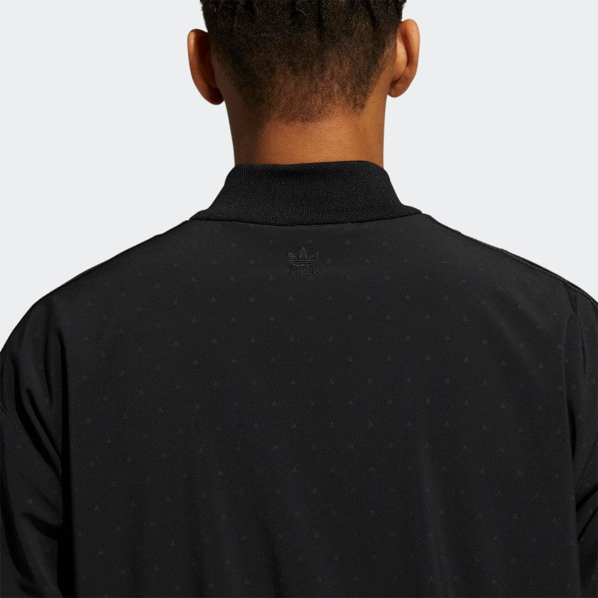 Close-up of the reflective print and tonal 3-Stripes on the adidas black athletic jacket