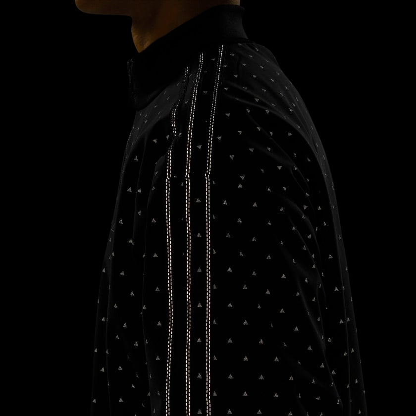 Model wearing the Pharrell x adidas black track jacket, highlighting its fit and reflective accents
